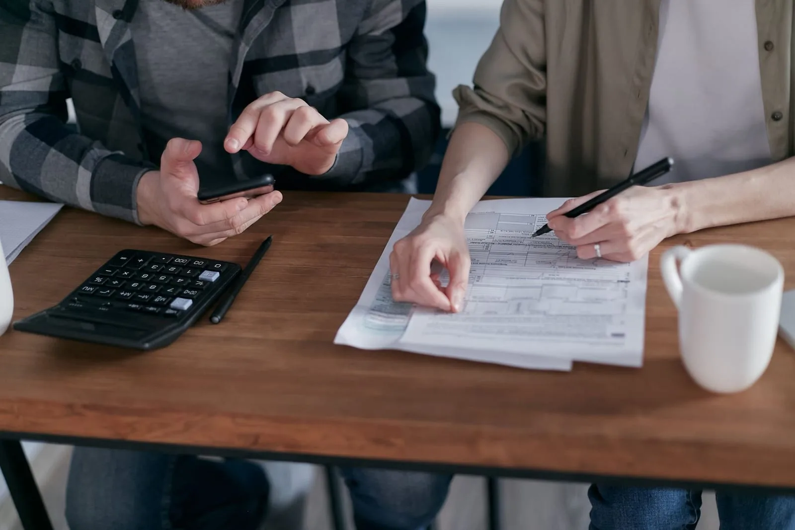 Documentos fiscais e calculadora sobre mesa para preparação da declaração de mais-valias no IRS em Portugal